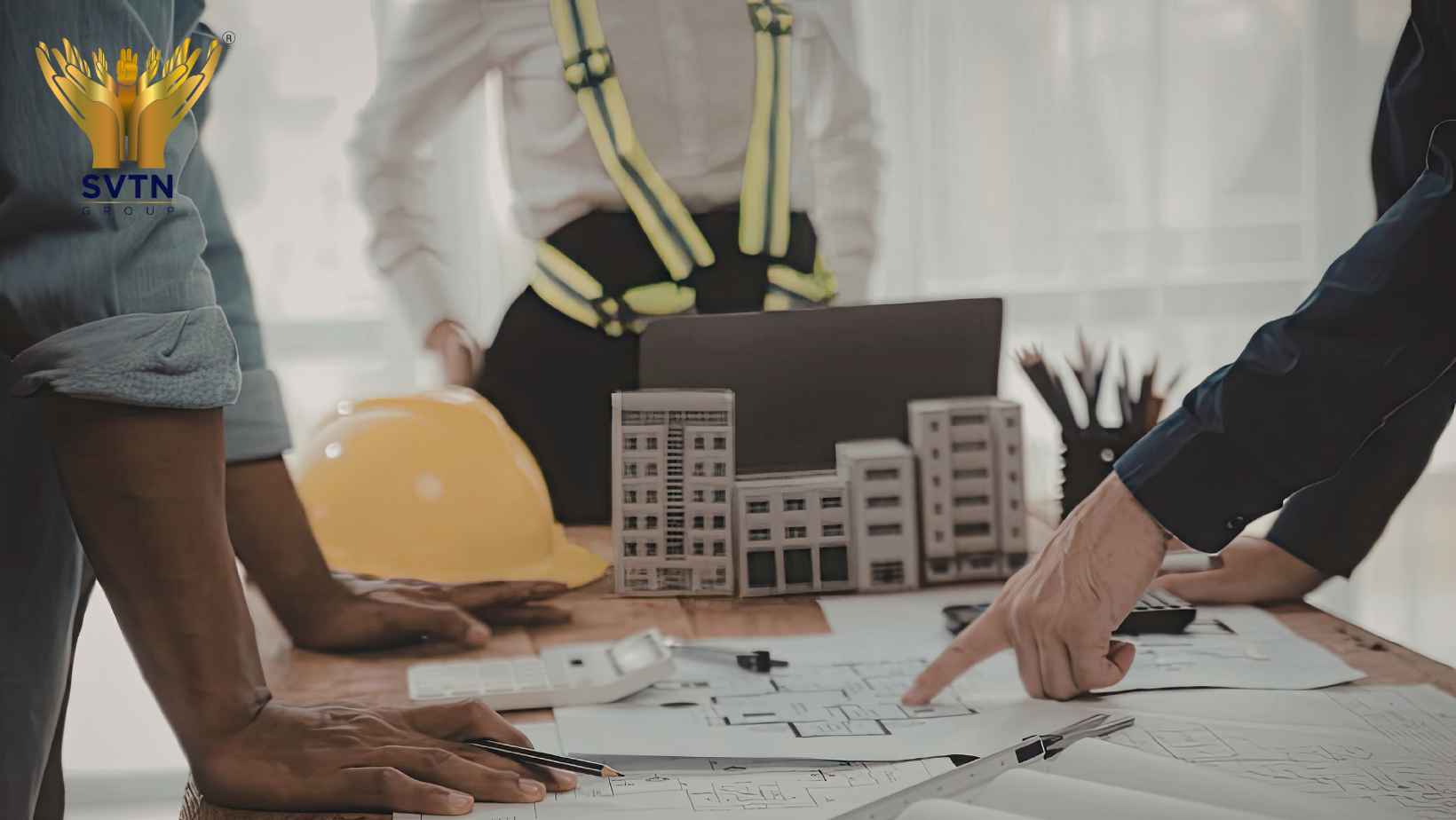 Construction professionals reviewing architectural plans at a building site, representing the advantages and disadvantages of turnkey construction projects.